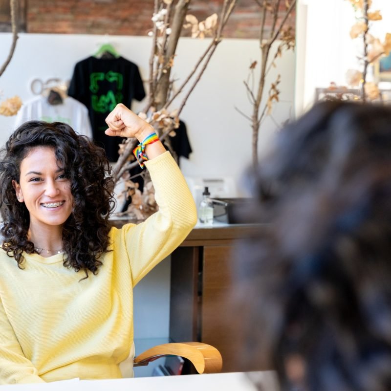 Woman gesturing empowerment in a hairdresser salon